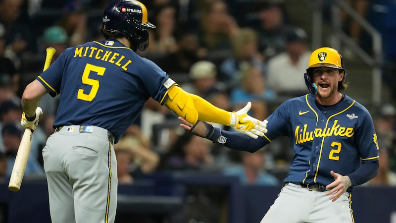 Milwaukee Brewers' Brice Turang celebrates after scoring on a single by Cooper Pratt during...