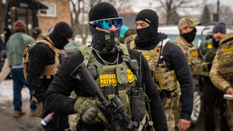 Federal agents stand guard, Wednesday, Jan. 21, 2026, in Minneapolis.
