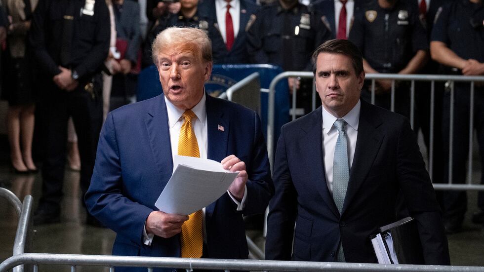 Then-former President Donald Trump, standing with defense attorney Todd Blanche, speaks at the...
